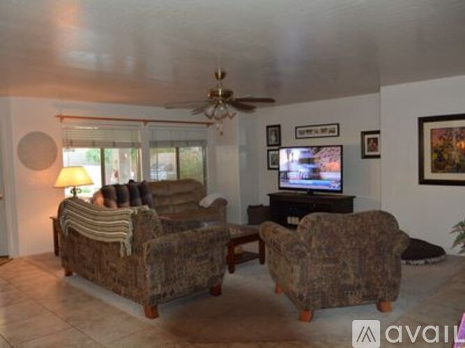 A living room with a couch, chair, and television.