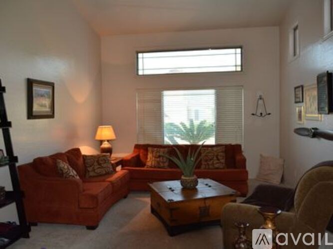 A living room with a red couch, a coffee table, and a lamp.