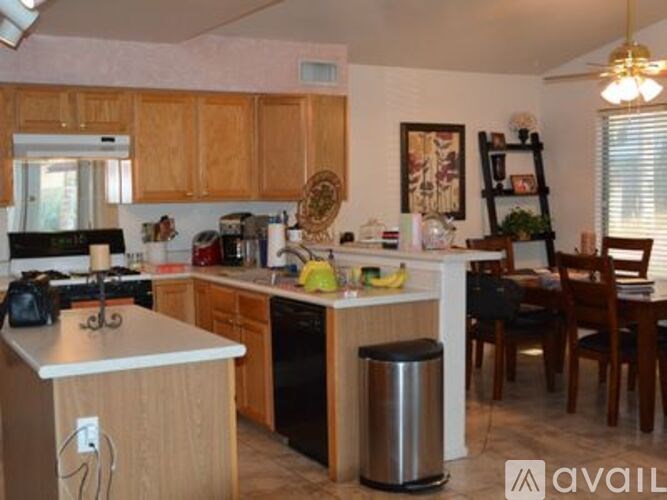 A kitchen with wooden cabinets and a dining table with chairs.