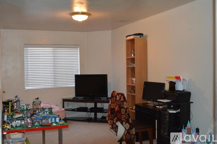A room with a desk, chair, and a computer.