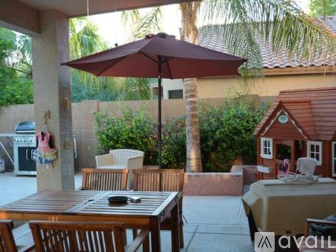 A patio with a table, chairs, and an umbrella.