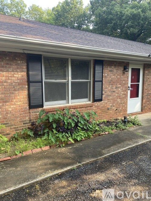 A red brick house with a white door and window.