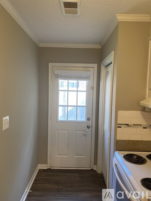 A white door with a window above it in a room.