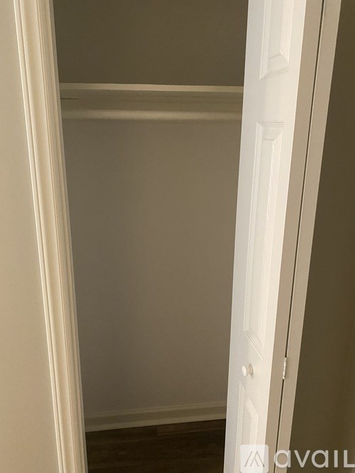 A white door is open to a room with a white wall.
