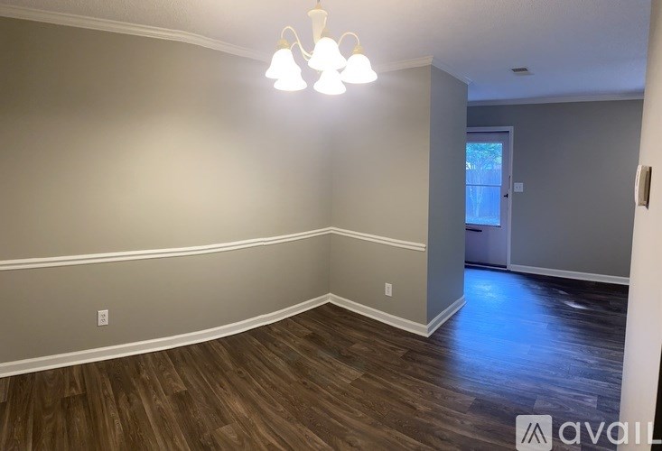 A room with wooden floors and a chandelier.