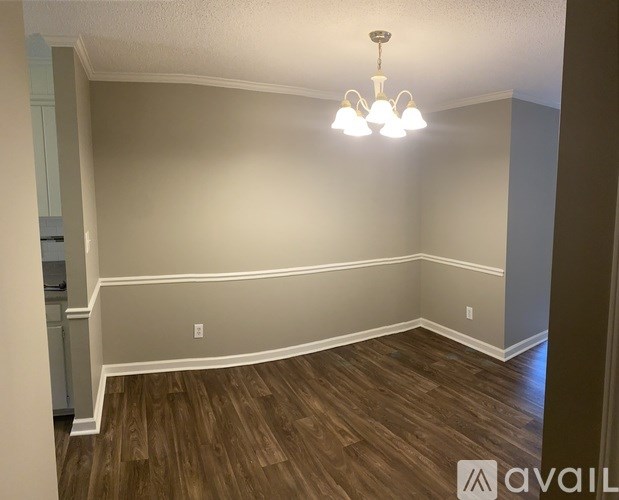 A room with wooden flooring and a chandelier.