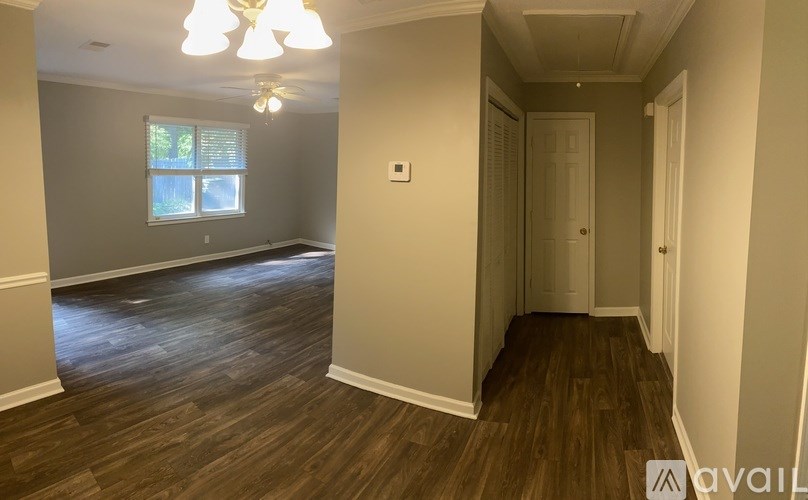 A room with wooden floors and a window with blinds.