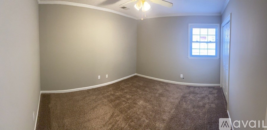 A room with a carpeted floor and a window.