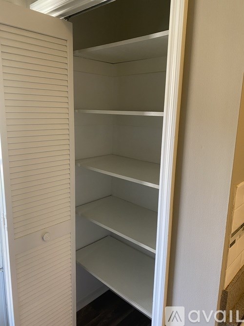 Empty white shelves in a pantry.