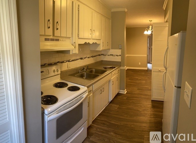 A kitchen with white cabinets and a stove top oven.