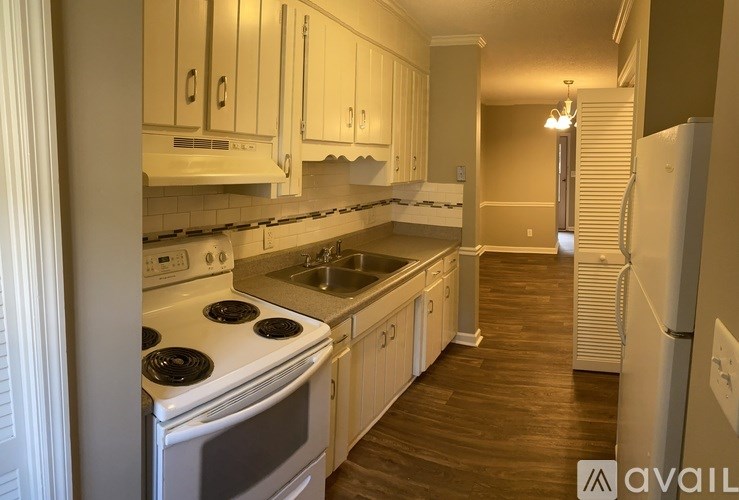 A kitchen with white cabinets and a stove top oven.