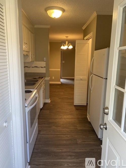 A kitchen with white cabinets and a white refrigerator.