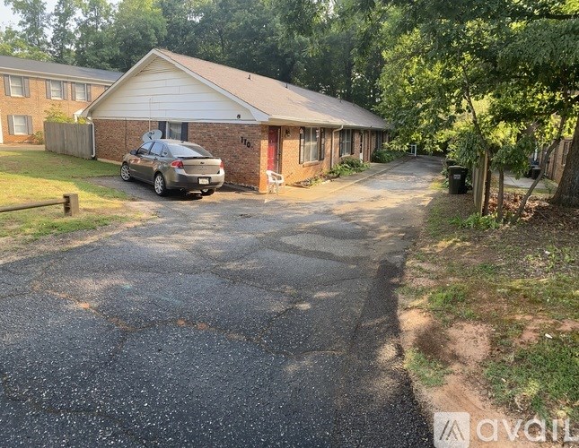 A house with a driveway and a car parked in front.