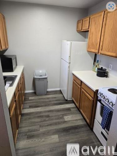 A kitchen with wooden cabinets and a white fridge.