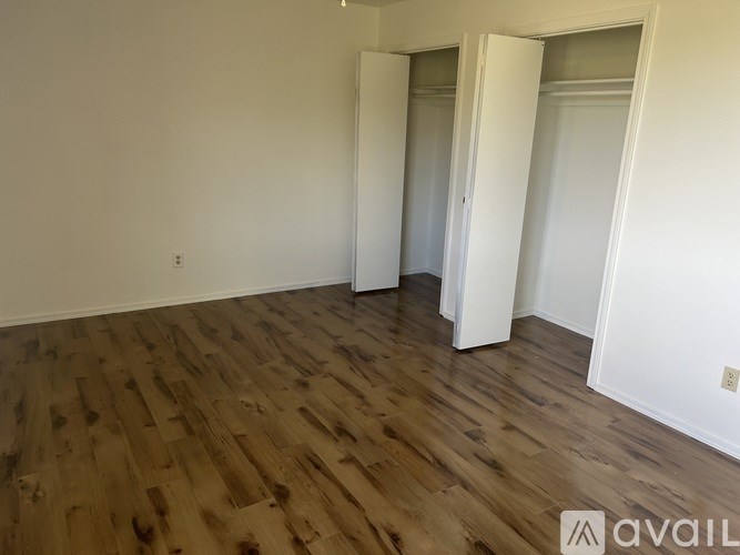 A room with wooden flooring and white walls.