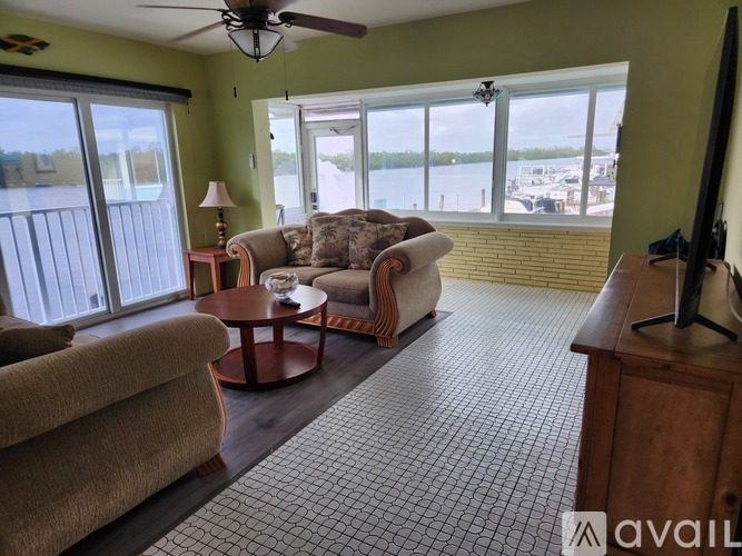 A living room with a couch, chair, and television.