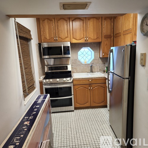 A kitchen with wooden cabinets and a stainless steel refrigerator.