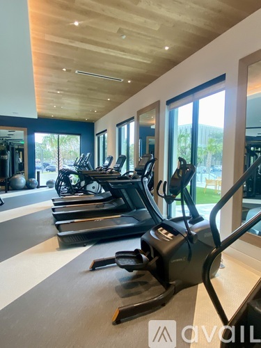 A gym with treadmills and a mirrored wall.
