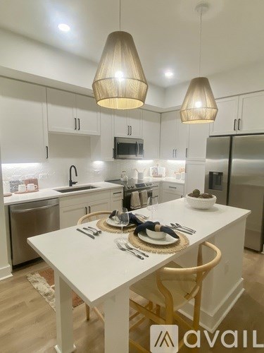 A modern kitchen with a dining table set for two.