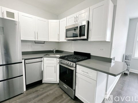 A kitchen with white cabinets and stainless steel appliances.