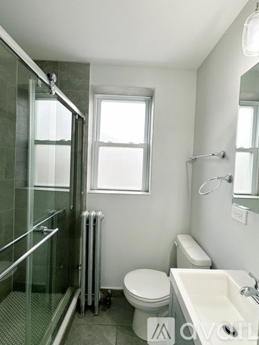 A white toilet sits next to a sink in a bathroom.