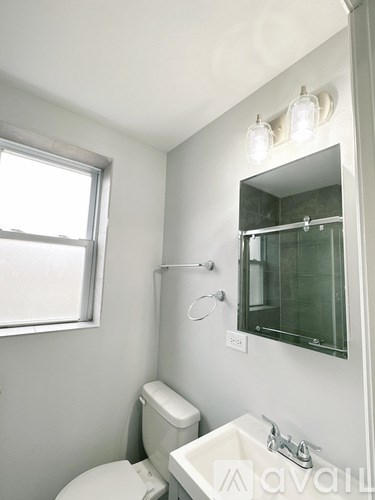 A white toilet sits next to a sink in a bathroom.