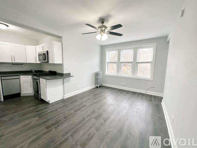 A kitchen with white cabinets and a black countertop.