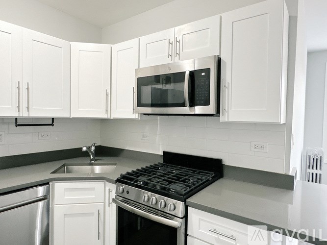 A kitchen with white cabinets and a black stove top.