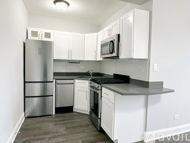 A kitchen with white cabinets and stainless steel appliances.