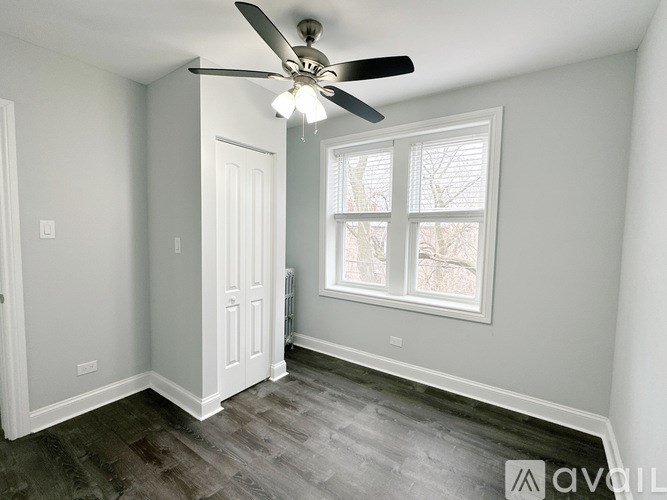A room with a ceiling fan and a window.