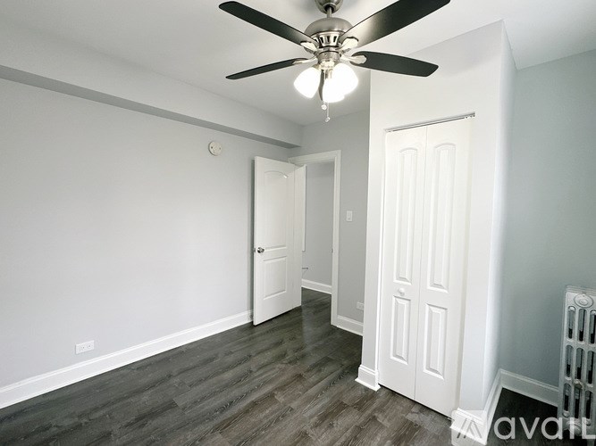 A room with a ceiling fan and a door.