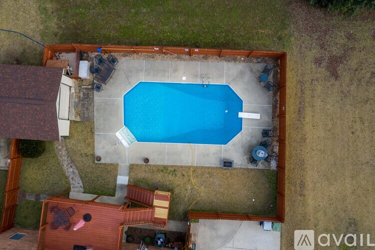A small pool surrounded by a concrete wall and a wooden deck.