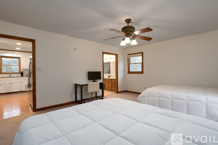 A bedroom with a large bed and a ceiling fan.