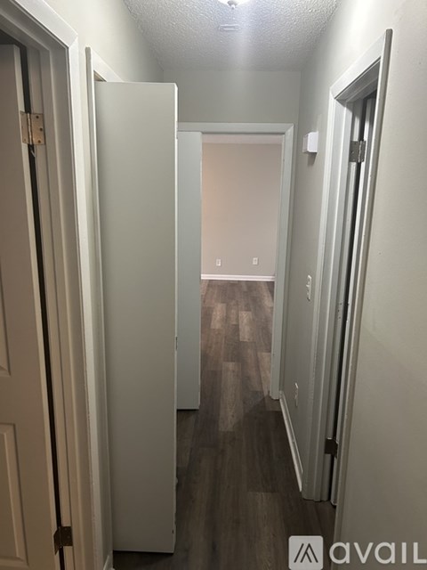 A hallway with a door on the left and another door on the right.