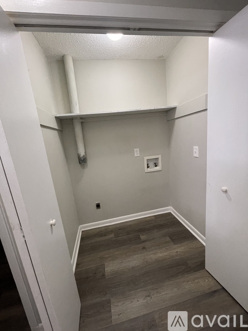 A small room with a wooden floor and white walls.