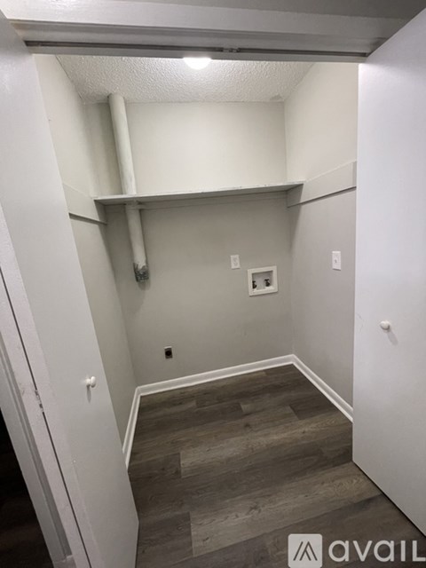 A small room with a wooden floor and white walls.