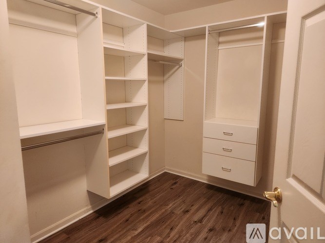 A white closet with shelves and drawers is available.