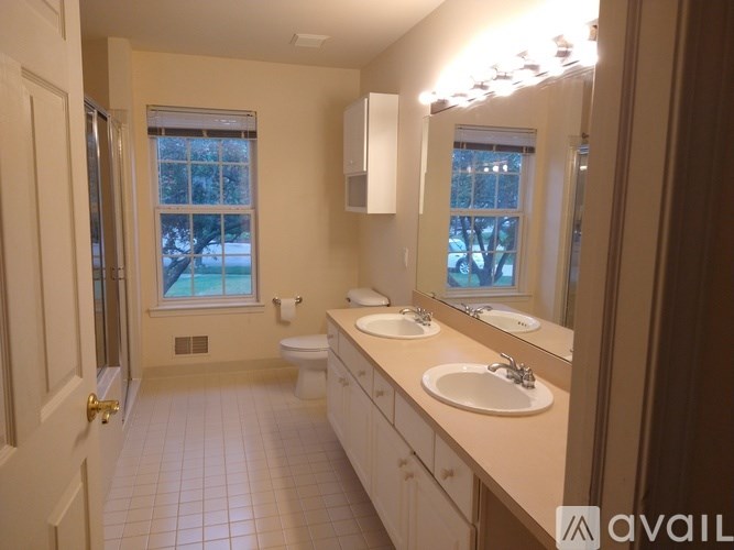 A bathroom with a toilet, sink, and mirror.