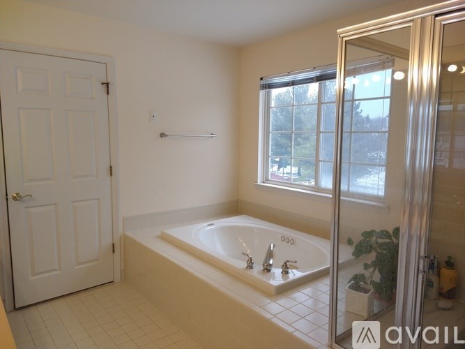 A bathroom with a bathtub, sink, and mirror.