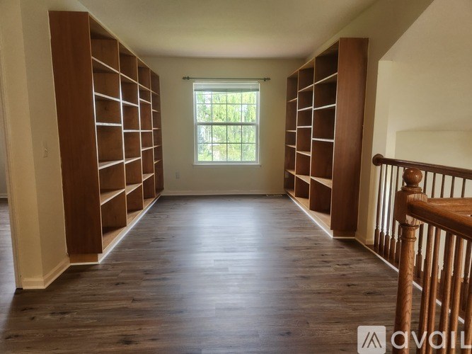 A room with wooden floors and shelving units.