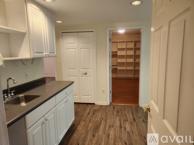 A kitchen with white cabinets and a sink.