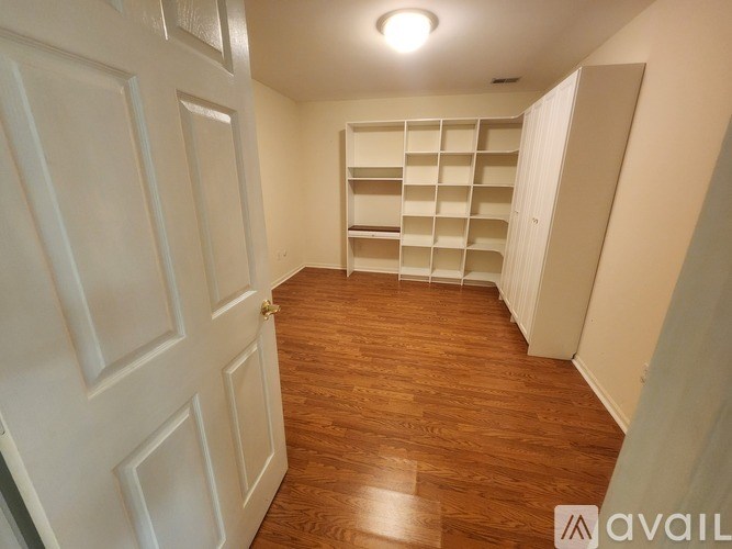 A room with wooden flooring and white walls.