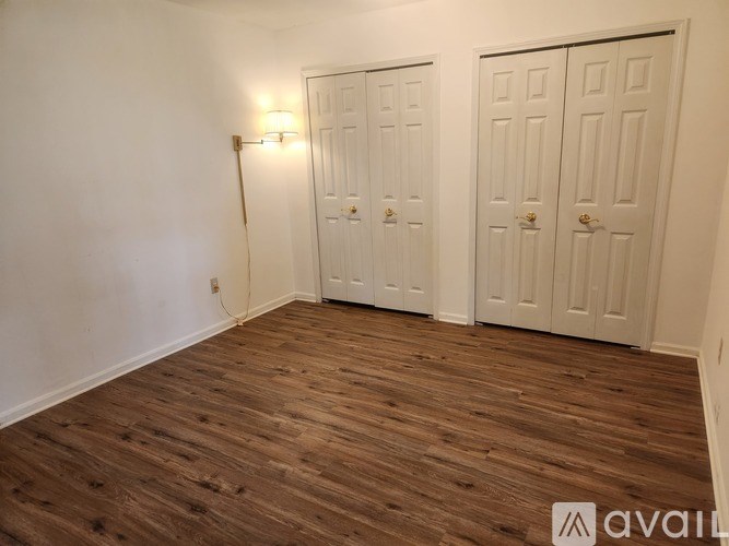 A room with two white doors and wooden flooring.