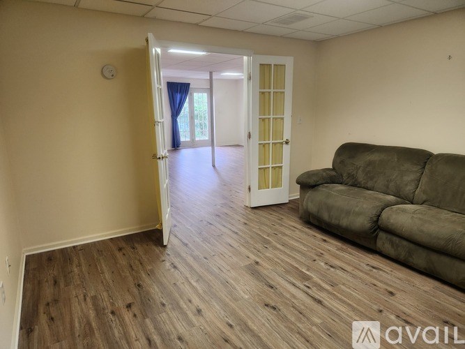 A room with a couch and a door leading to another room.