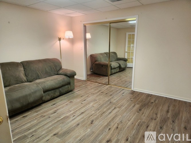 A room with a grey couch and a wooden floor.