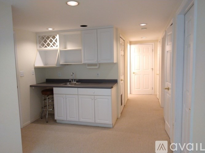A kitchen with white cabinets and a black countertop.