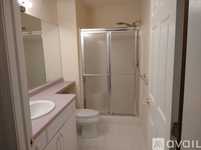 A bathroom with a toilet, sink, and shower stall.