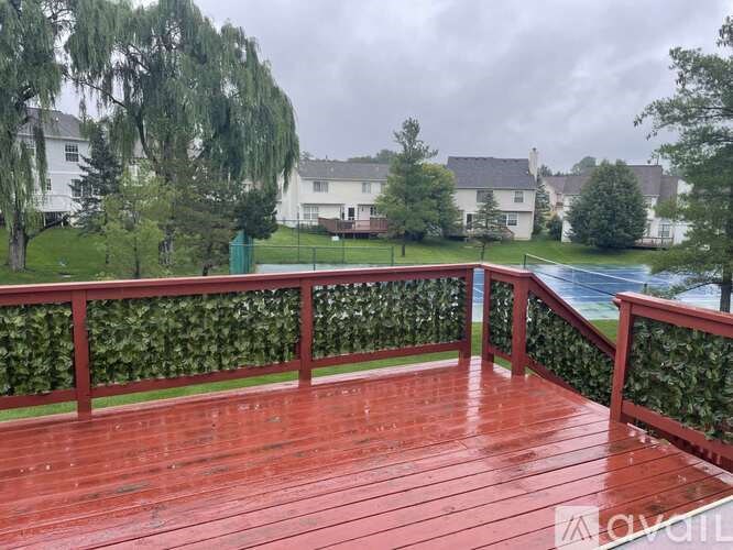 A wooden deck with a railing and a wet surface.