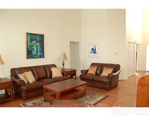 A living room with two brown leather couches and a coffee table.