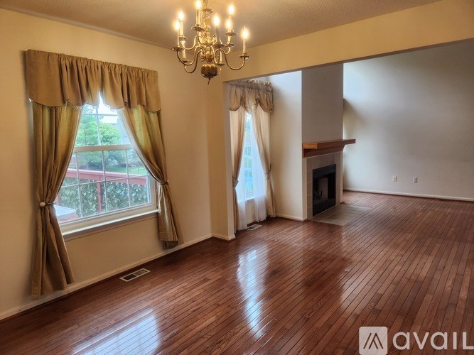 A room with wooden floors and a chandelier.